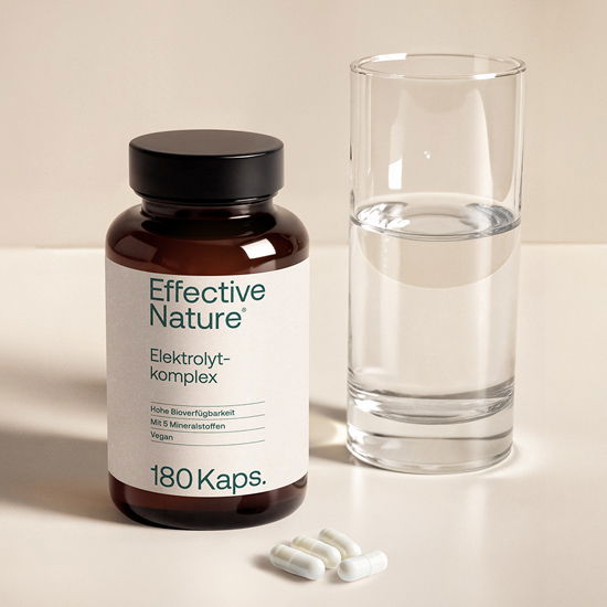 Elektrolytkomplex von Effective Nature mit 180 veganen Kapseln für hohe Bioverfügbarkeit, abgebildet neben einem Glas Wasser.