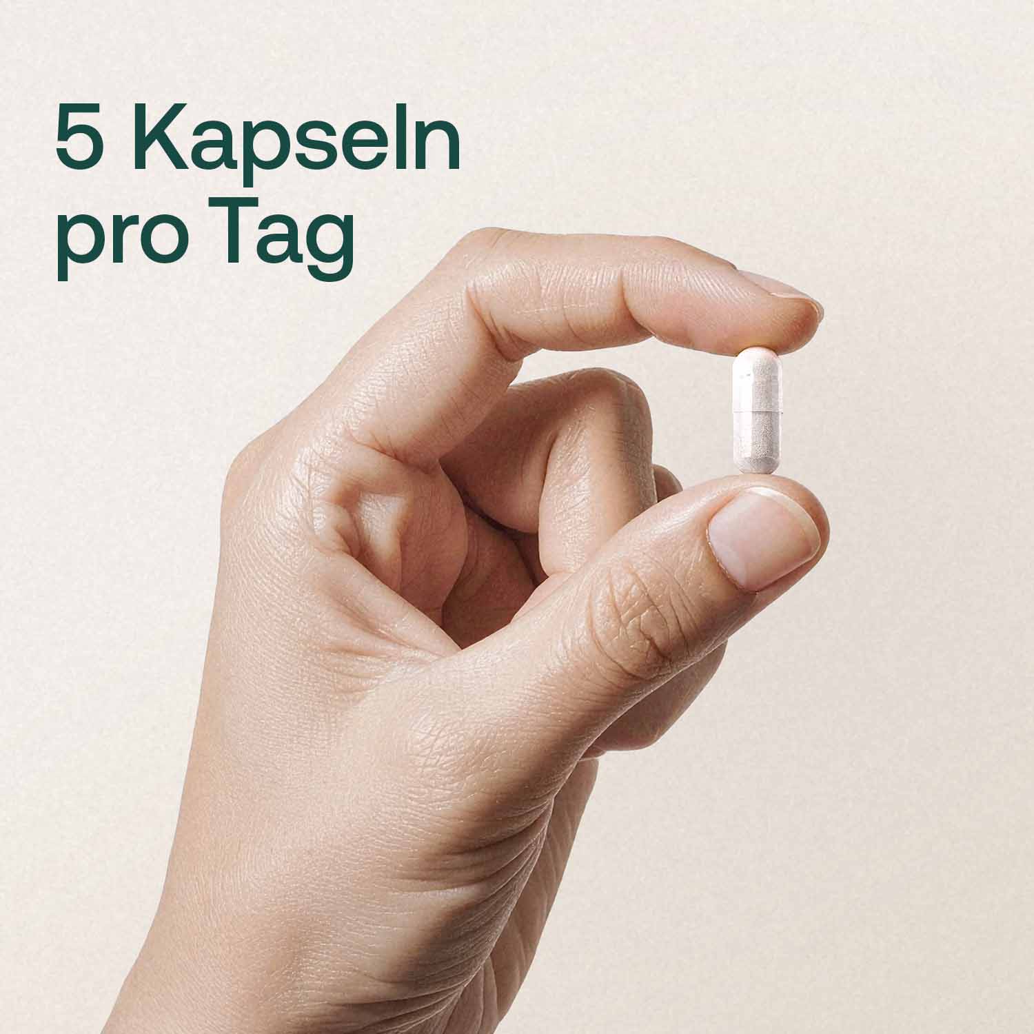 Hand hält Kapsel mit Text 5 Kapseln pro Tag