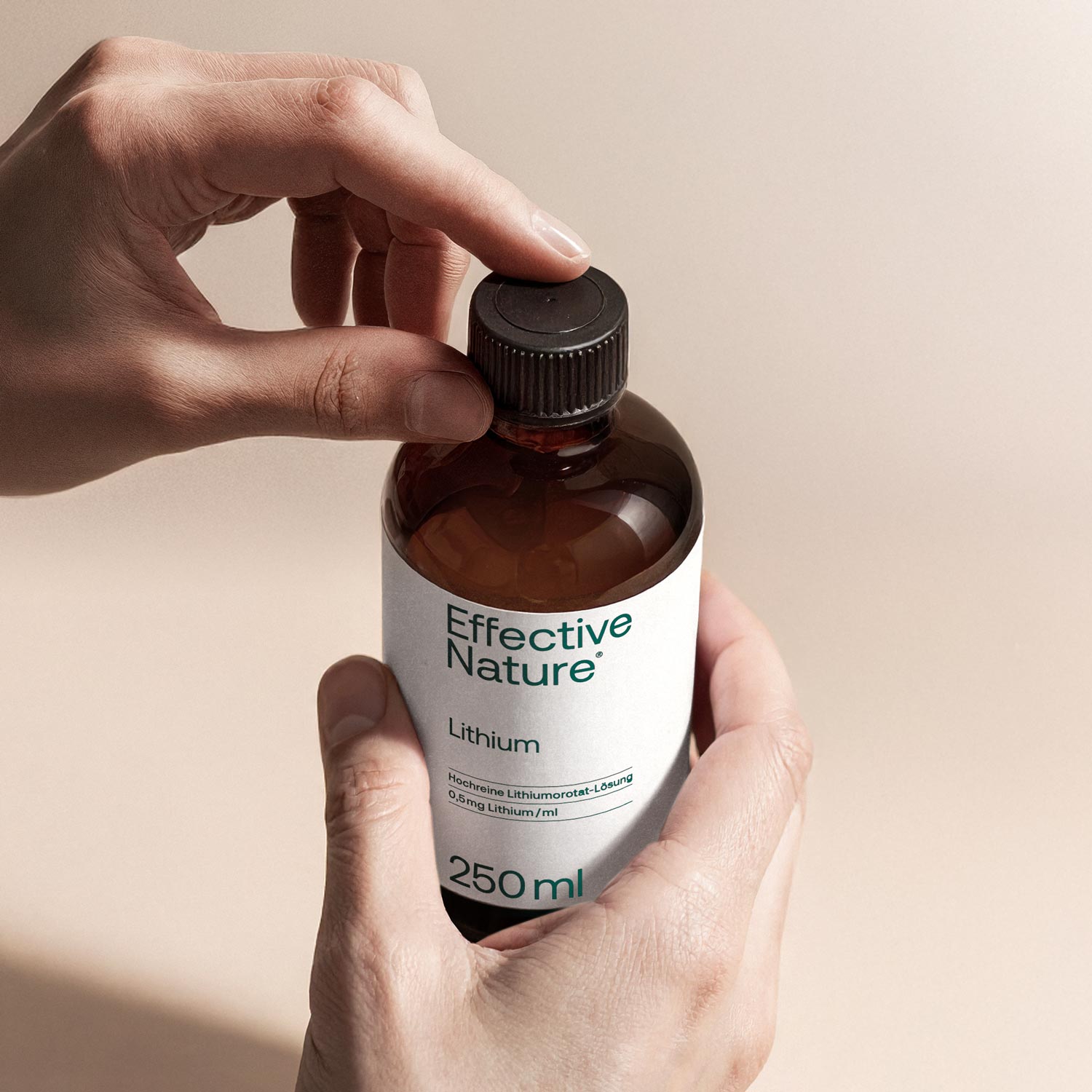 Hand hält eine Flasche Lithium Lösung von Effective Nature, 250 ml