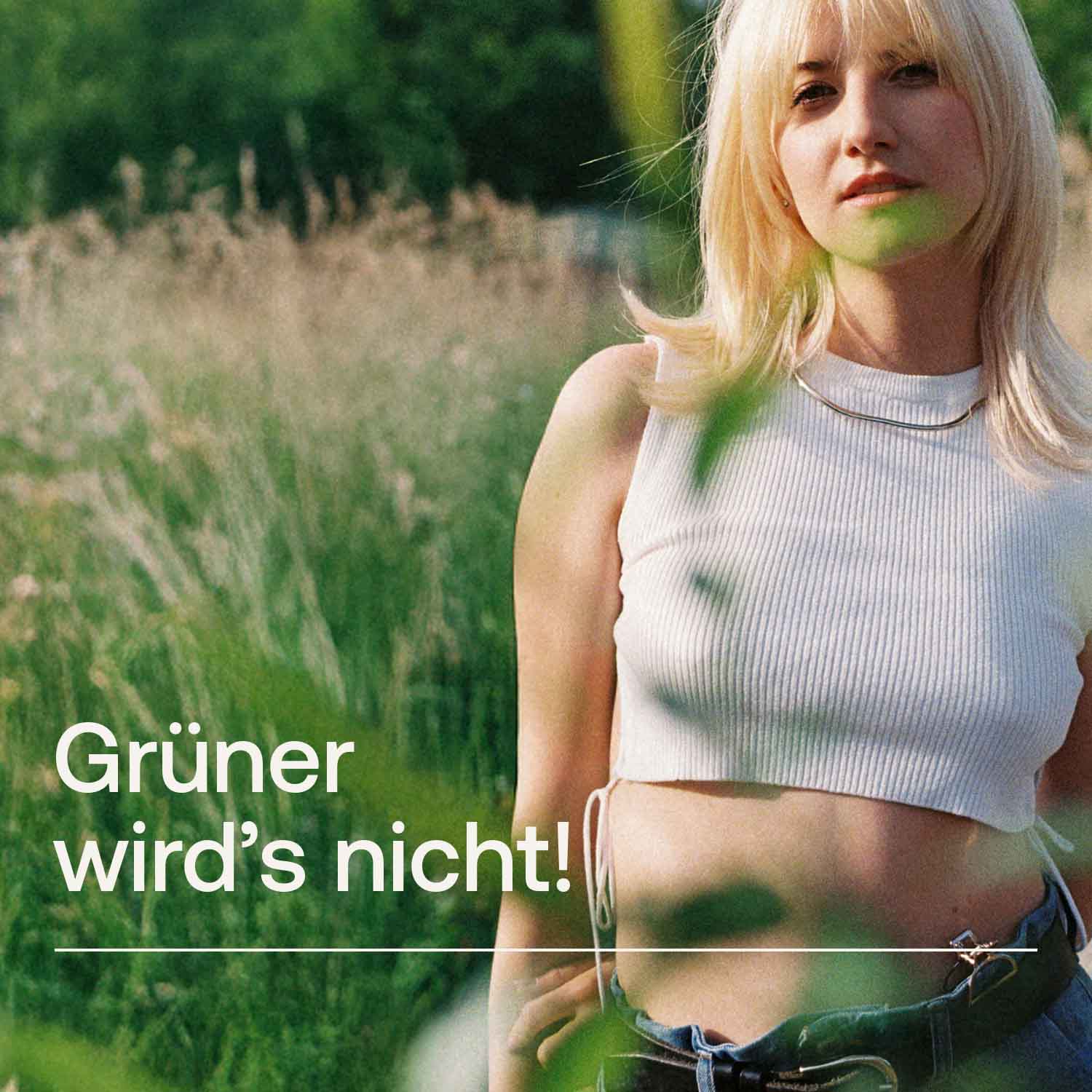 Eine Frau steht in hohem Gras, Text auf dem Bild lautet "Grüner wird's nicht"