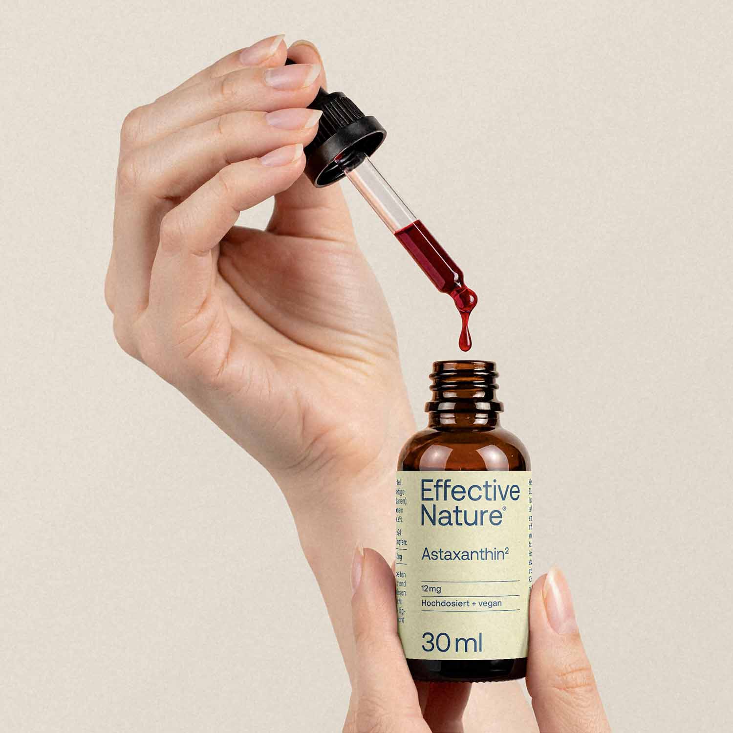 Jemand tropft Astaxanthin mit einer Pipette in die Flasche