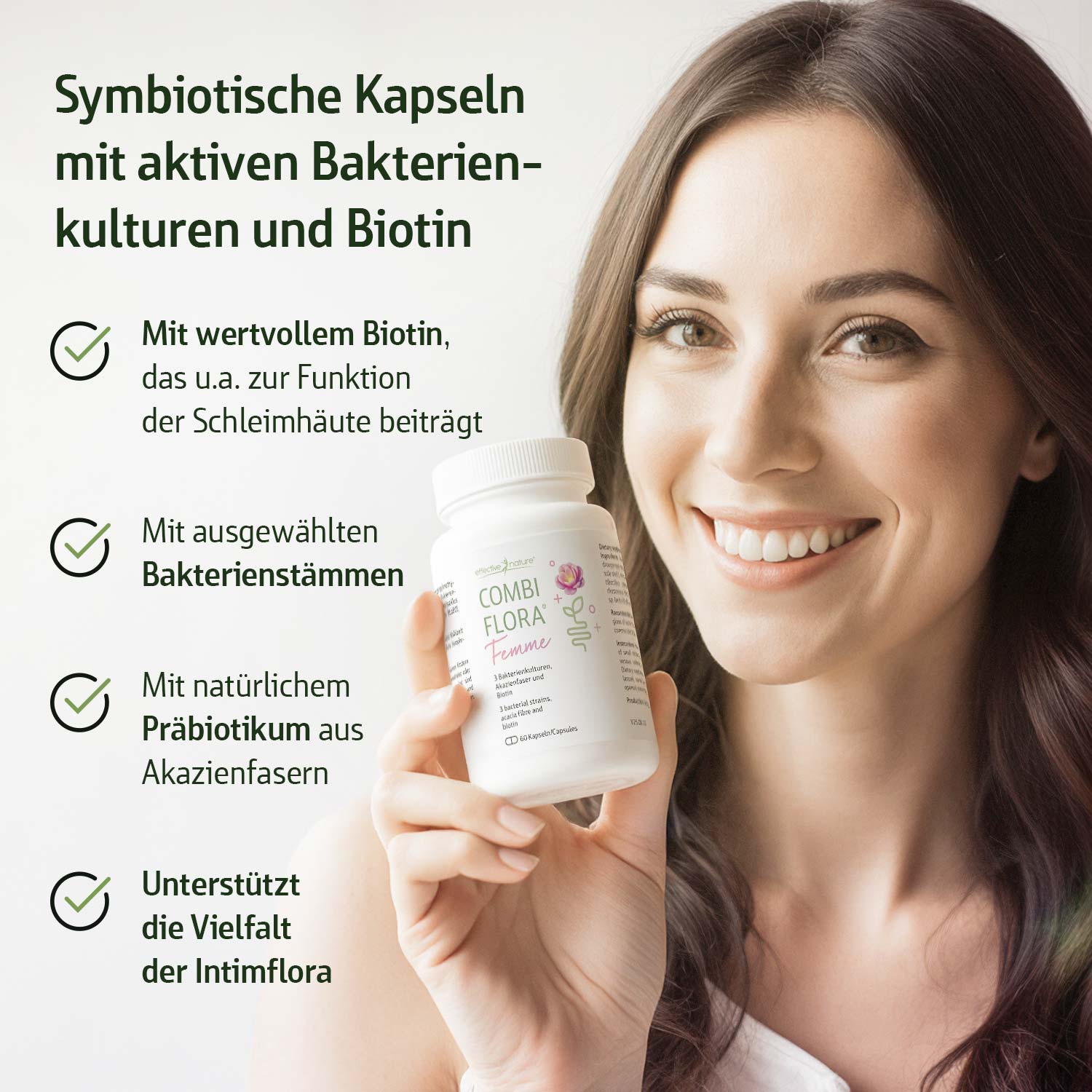 Frau hält eine Flasche symbiotischer Kapseln mit Biotin vor hellgrünem Hintergrund