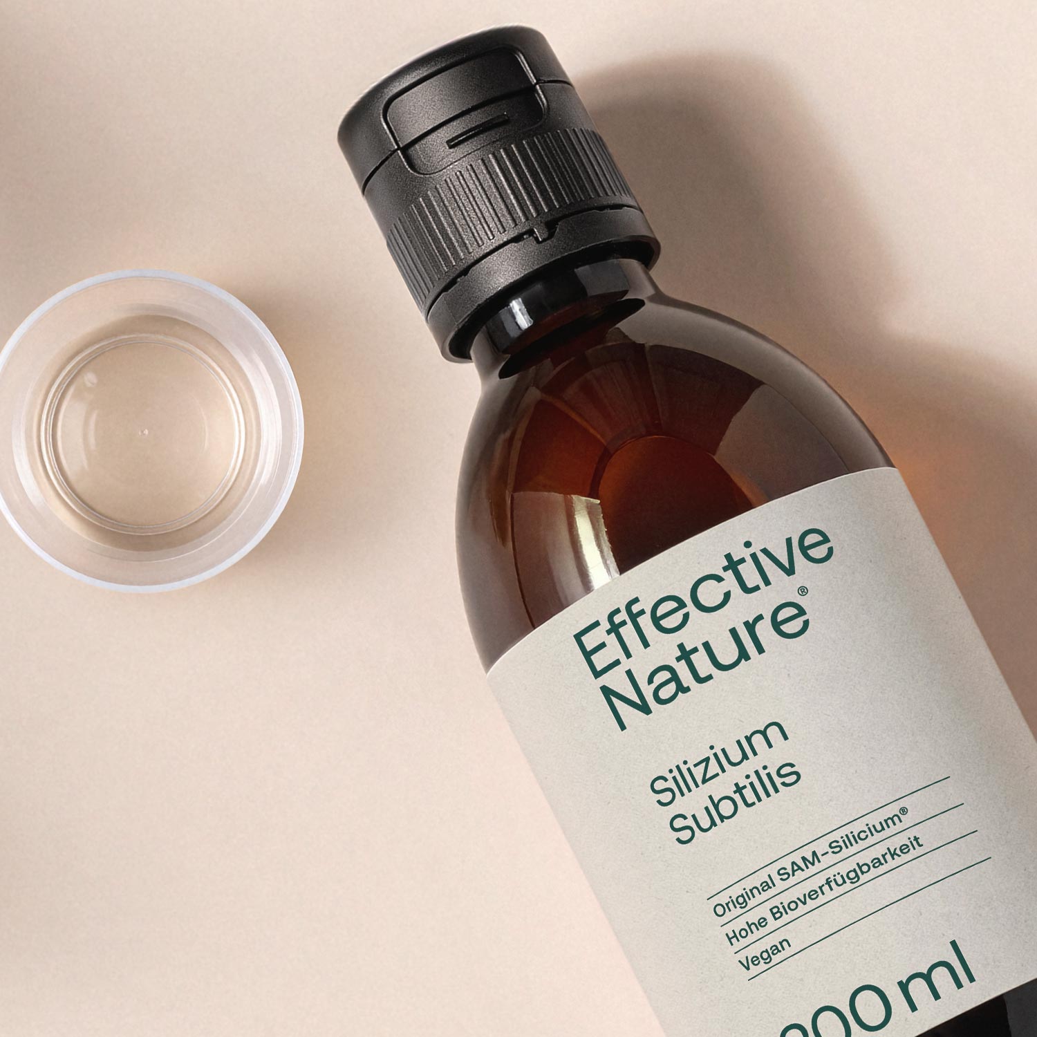 Flasche Silizium Subtilis von Effective Nature neben einem Messbecher auf beigem Hintergrund