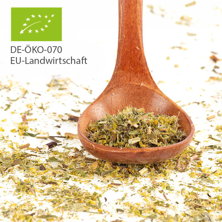 Nahaufnahme einer Bio-Kräuterteemischung in einem hölzernen Löffel mit EU-Bio-Siegel DE-ÖKO-070