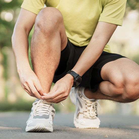 Mann schnürt sich die Laufschuhe