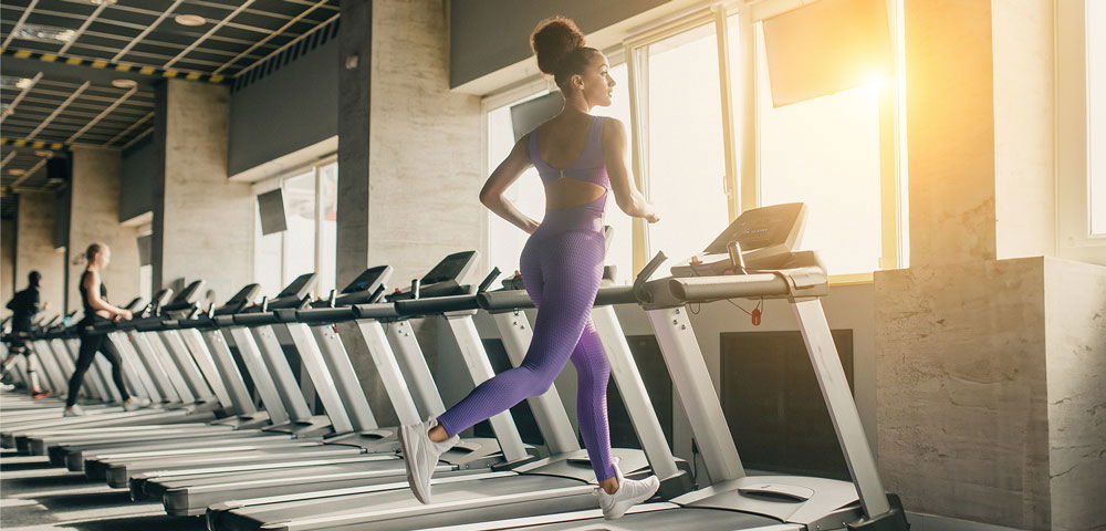 Eine Frau läuft im Fitnessstudio auf einem Laufband