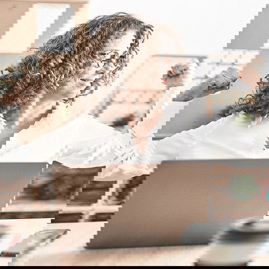 Frau streckt sich vorm Computer