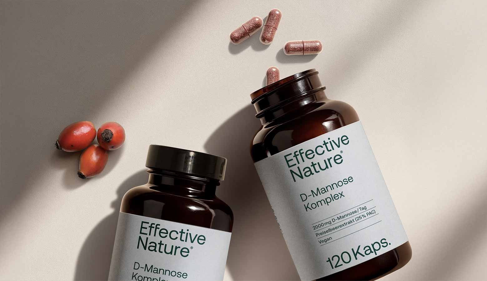 D-Mannose-Komplex von Effective Nature Zwei Dosen D-Mannose und einzelne Kapseln auf einem Tisch