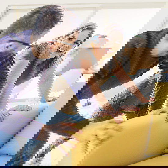 Ein junges Paar beim Heimtraining am Sofa