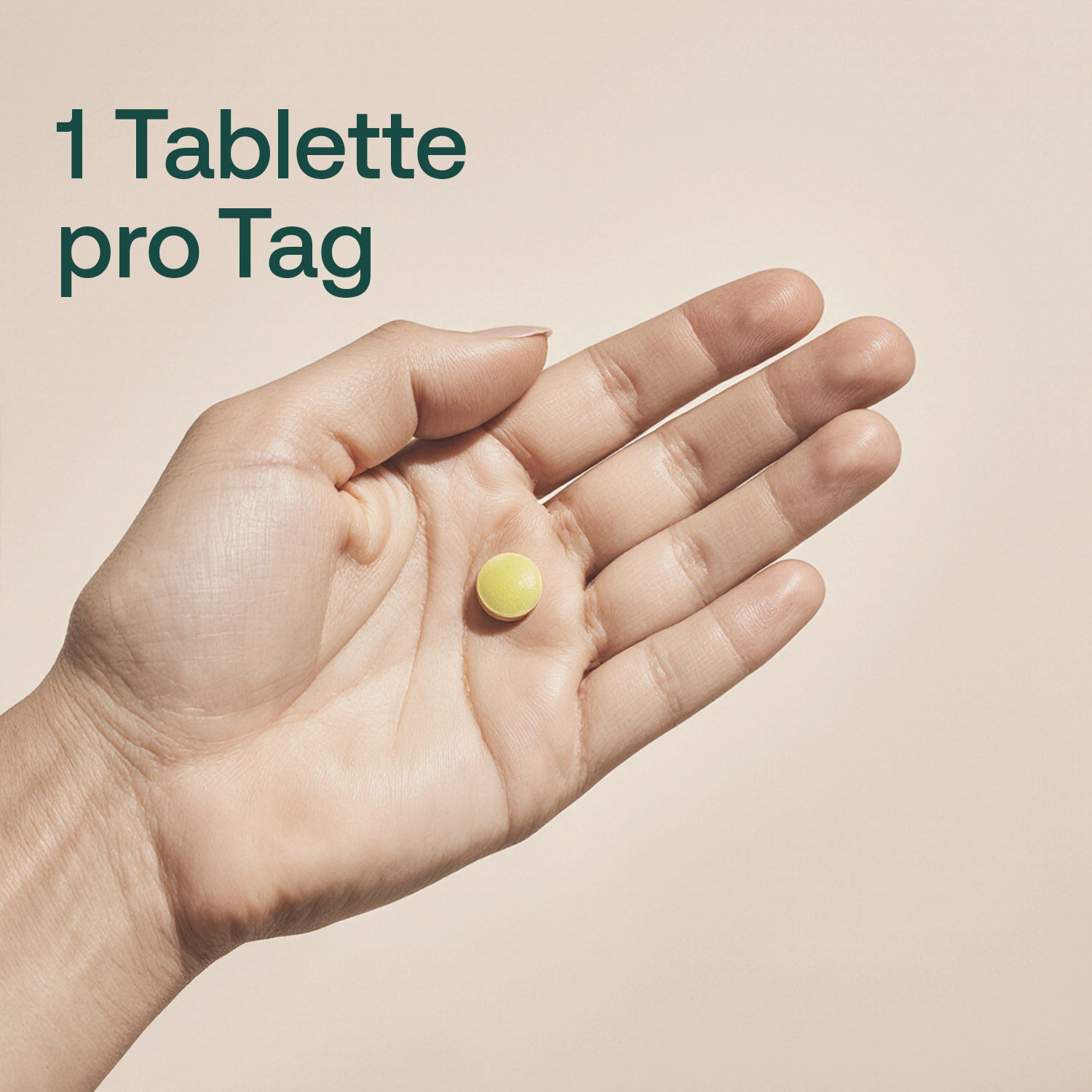 Hand hält eine kleine gelbe Tablette, Text: Eine Tablette pro Tag