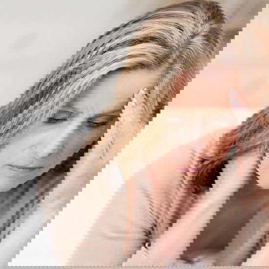 Eine Frau hält sich müde oder konzentriert die Stirn