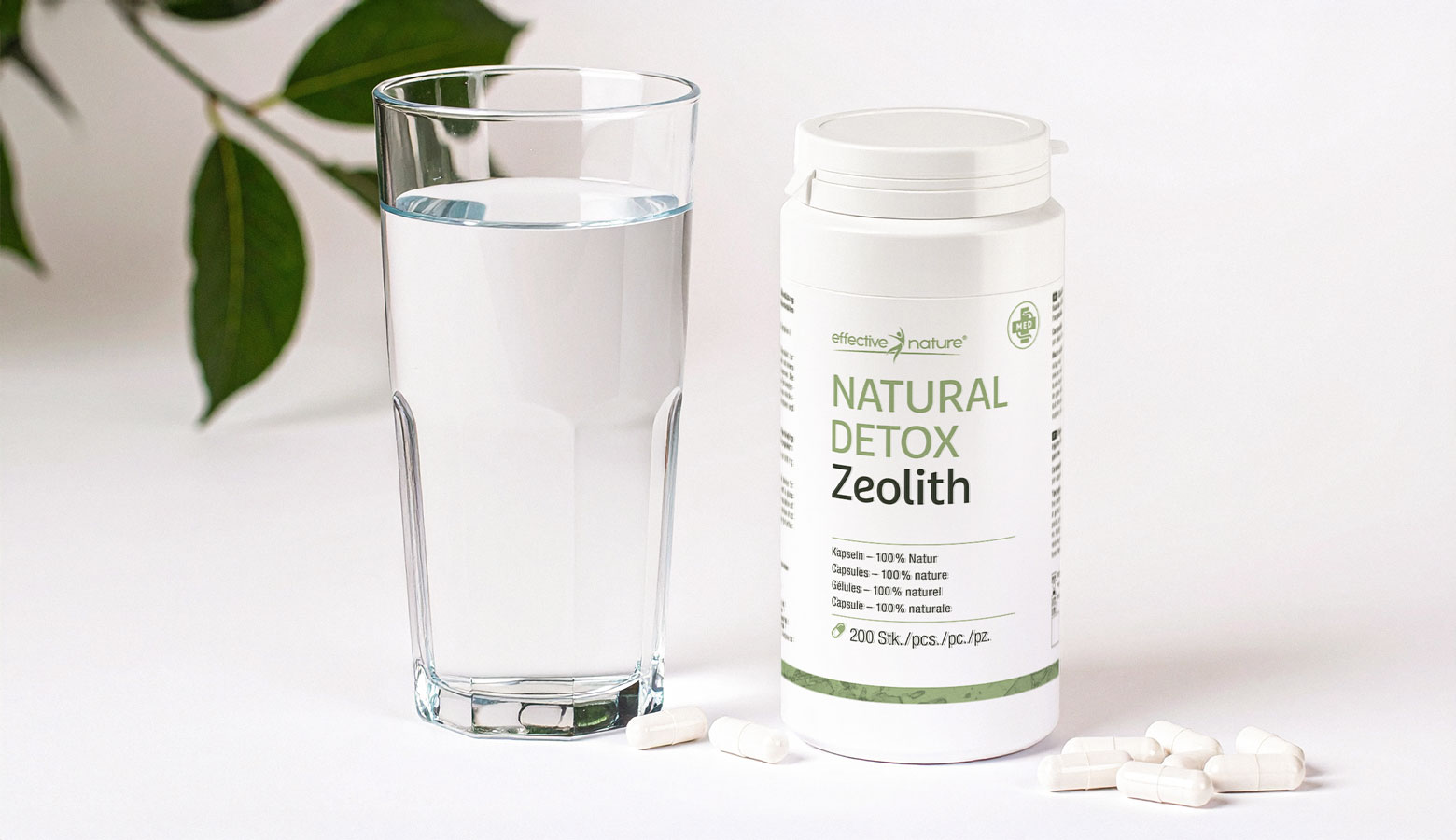 Natural Detox Zeolith neben einem Glas Wasser auf einem Tisch