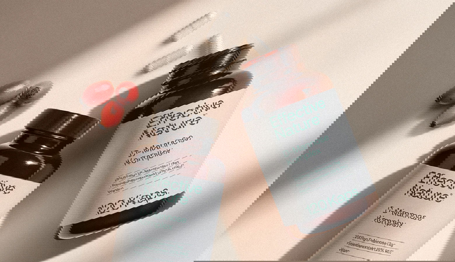 D-Mannose-Komplex von Effective Nature Zwei Dosen D-Mannose und einzelne Kapseln auf einem Tisch