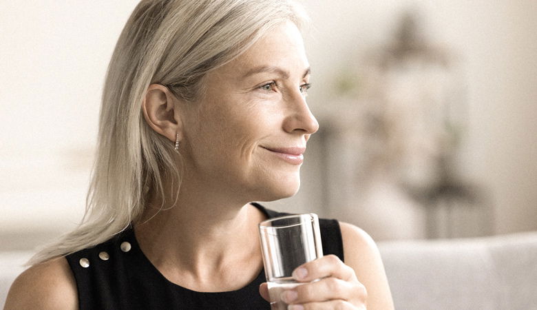 Eine Porträtaufnahme einer Frau mit einem Glas in der Hand