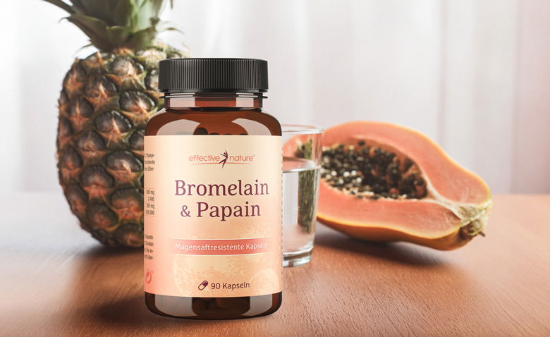 Eine Dose Bromelain & Papain vor eine Ananas und einer Papaya auf einem Tisch