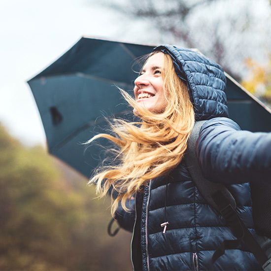 Frau in dicker Jacke in Natur