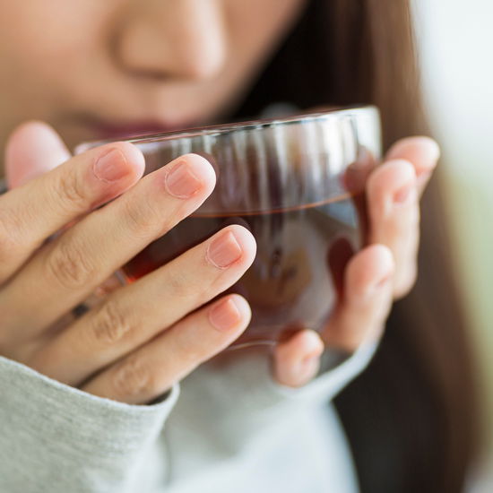 Eine Frau trinkt aus einer Tasse