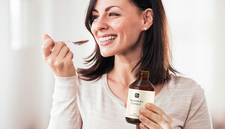 Frau mit Löffel und liposomalem Vitamin C von effective nature